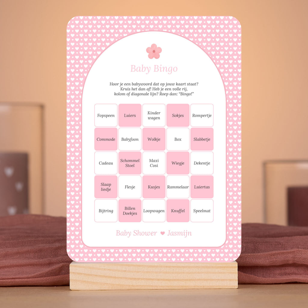 Baby Bingo kaart met witte hartjes op roze achtergrond en bloemaccent – sfeervolle setting met babyshower decoratie – Studio Miron