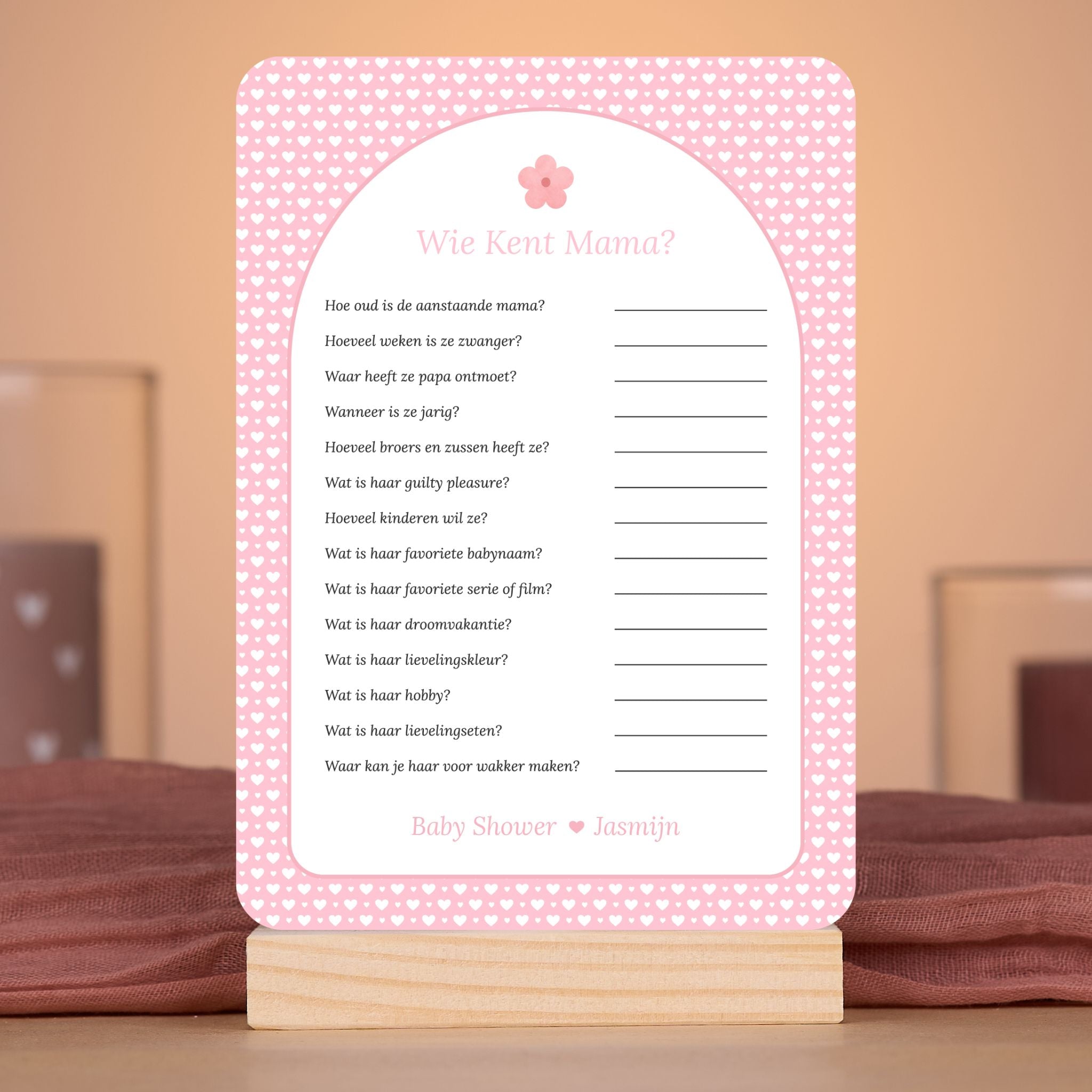 Wie kent Mama? kaart met witte hartjes op roze achtergrond en bloemaccent – sfeervolle setting met babyshower decoratie – Studio Miron